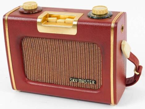 A vintage Sky Master radio, in pressed leather case with gilt coloured highlights, with Ever Ready label and fitted interior, hinging to the back, 20cm W.