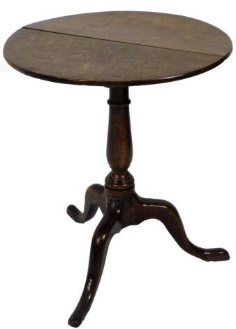 An 18thC oak tilt top table, the circular top raised on a baluster section terminating in triple cabriole legs, 70cm H, 61cm Dia.