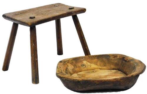 An early 20thC rustic dough bowl, of shaped form, 43cm W and a pegged stool. (2)