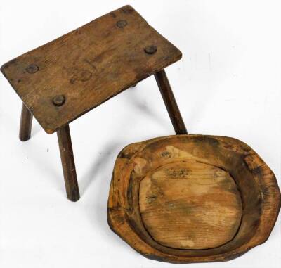 An early 20thC rustic dough bowl, of shaped form, 43cm W and a pegged stool. (2) - 2