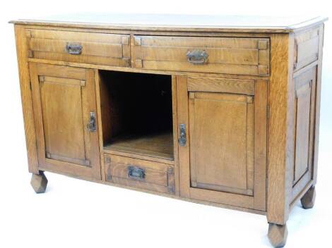 An early 20thC oak side cabinet, with a partially carved top above two frieze drawers and central opening, with further drawer beneath flanked by double cupboards, on shaped feet, 97cm H, 151cm W, 55cm D.