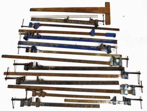 Various metalware, industrial sash clamps, with articulated ends, some painted blue, 31cm W and two measuring rules, comprising of a wooden example with T bar end and a metal example. (a quantity)