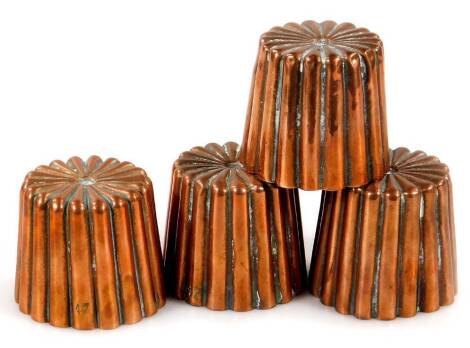 A set of four small Victorian jelly or fondant moulds, each with ribbed decoration, 4.5cm high and another similar. (4)