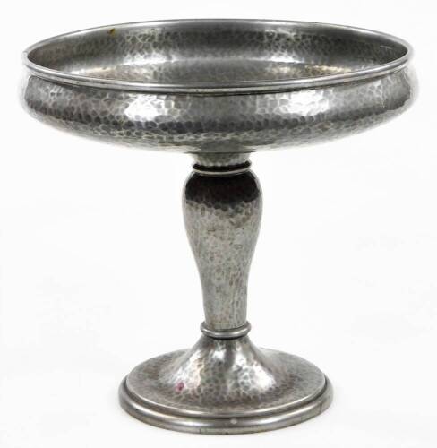 A BCM Tudric pewter tazza, the shallow circular bowl on a baluster stem and circular foot, partially hammered, impressed and numbered 01670 beneath, 18cm H.