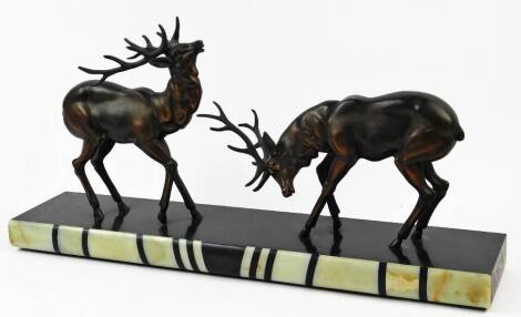 An Art Deco spelter and marbled figure group of rutting deer, on a black ground with coloured marble front, signed Simonisin 35cm high.