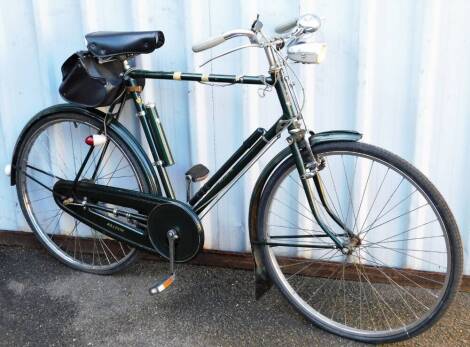 A vintage gentleman's Raleigh bike, in green with chrome trim, leather saddle, front and back dynamos and bell, 106cm high, three speed, with original receipt.