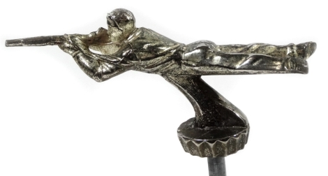 A 20thC chrome plated car mascot, in the form of a soldier, in lying position holding gun, with mount, 13cm wide.