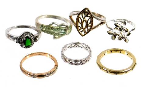 Seven modern dress rings, comprising three silver dress rings, one twist design wedding band, a ting stone set eternity ring, and a green and white stone set cluster ring, and four rolled gold or silver plated dress rings. (7)