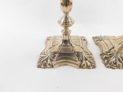 A pair of Georgian style silver candlesticks, of fluted and embossed foliate form, 23cm H, Harrods Ltd (Richard Woodman Burbridge), Sheffield 1958, 23cm H, 44.05oz. - 2