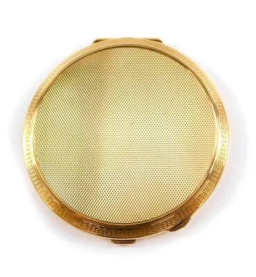 A 9ct gold circular cased compact, with engine turned decoration, opening to reveal an internal mirror and powder recess, Turner & Simpson Ltd, Birmingham 1984, 101.2g all in, cased.