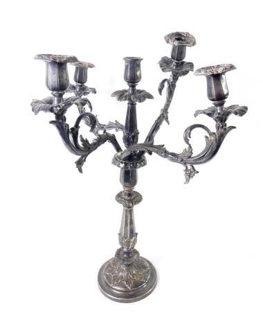 An early 19thC Sheffield plate five branch candelabrum, with leaf scroll arms and flower head drip trays, the candlestick base of fluted and embossed foliate form, on a circular base, 55cm H.
