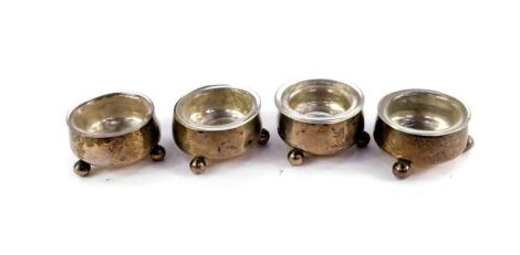 A set of four late Victorian plain silver circular salts, each with ball feet, with glass liners, (AF) London 1895, weighable silver 3ozs.