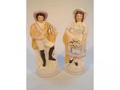 A pair of late 19thC Staffordshire pottery figures of a moustachioed fisherman and wife