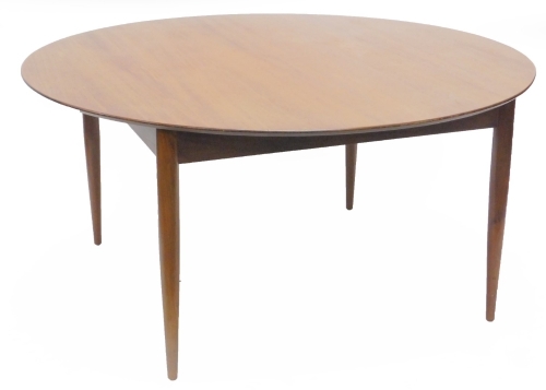 A retro Danish teak dining table, the circular top on turned tapering legs, 150cm dia.