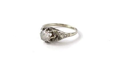 A diamond solitaire ring, in raised basket setting, with round brilliant cut diamond, with eight claws, approx 0.47ct, with tiny diamond chip set V shaped shoulders and pierced shoulders, on a plain white metal band, marked 18ct, ring size O, 2.9g all in.