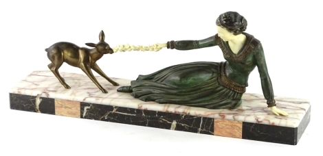 A French Art Deco spelter figure group, cast in the form of a reclining lady with a fawn, on a verigated marble rectangular base, 58cm L.