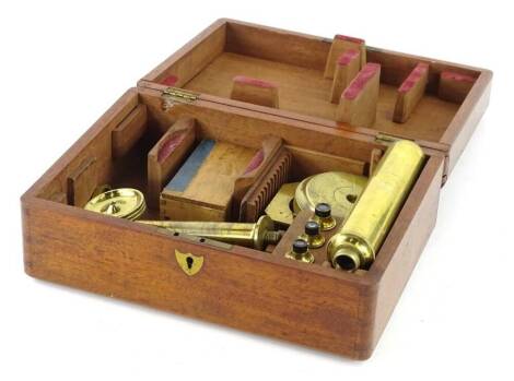 An early 20thC brass folding students type microscope, in mahogany case, 24cm W.