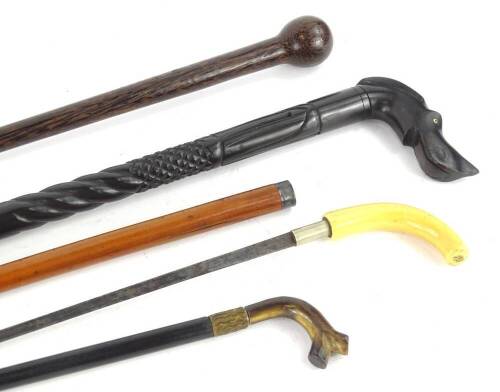 A collection of walking sticks, to include a late 19th/early 20thC Malacca sword stick, with ivory handle, an African carved ebony stick with dog shaped handle, a parasol handle in ebony and horn, etc.