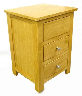 An ex shop floor solid oak bedside cabinet, with three drawers, 43cm W.