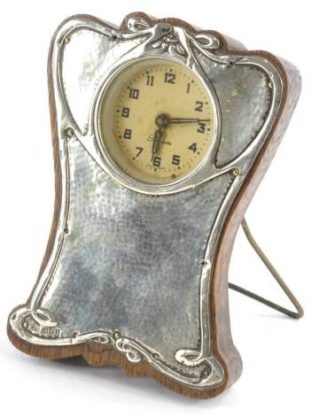 An Art Nouveau style silver mounted timepiece, the shaped case decorated with scrolls and with hammered decoration, German movement, Birmingham 1907, 15.5cm H.