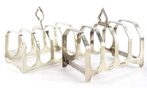 Two similar silver four division toast racks, each with a pierced handle, 3oz.