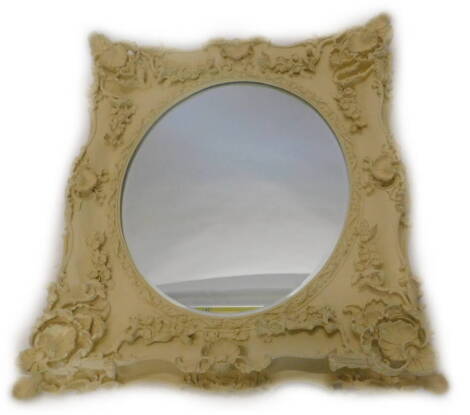 A cream painted wall mirror, decorated with foliate scrolls, shells, flowers, etc., surrounding an oval bevelled mirror plate, 76cm x 88cm.