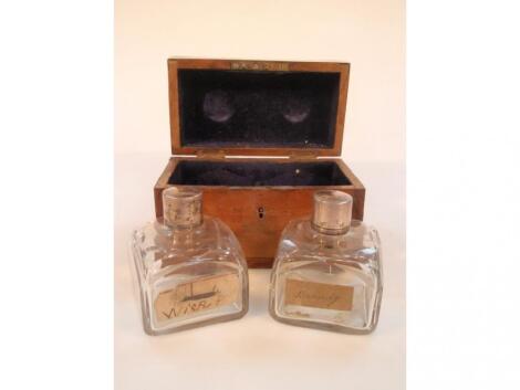 A 19thC mahogany box containing two slice cut glass square bottles with