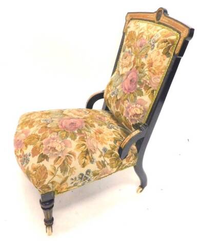 A late Victorian ebonised and walnut veneered nursing chair, the shaped back inset with a Wedgwood Jasperware back, with a padded back and seat on turned tapering legs with ceramic castors.