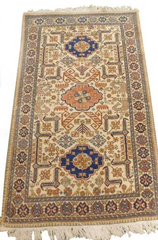 A Persian type rug, with a design of medallions on a beige ground, decorated with birds, etc., one wide and two narrow borders, 145cm x 86cm.