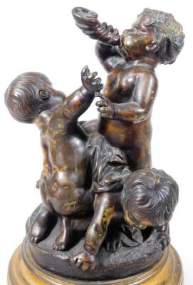 A pair of bronze groups of putti, one featuring a central putto blowing a horn, a second reaching up, a third on all fours beneath, circular base, on a circular brass socle, the other with standing putto holding a leaf, 28cm H. - 2