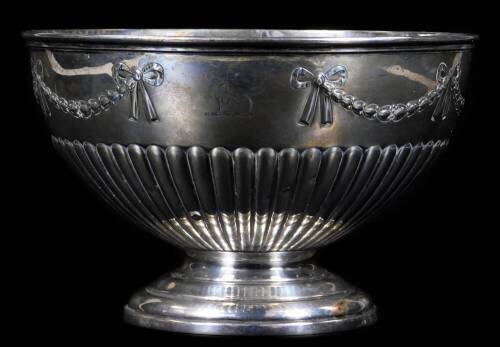 A Victorian silver rose bowl, by PE & Sons, with moulded rim, embossed and chased body, with an upper band of husk and berry swags tied with bows, on an inverted stem and circular stepped foot, with engraved greyhound crest, London 1897,14cm H, 16oz.