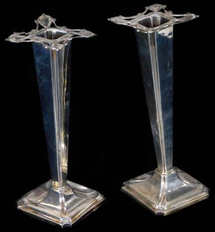 A pair of Edwardian silver candlesticks, each with pierced floral tops, tapering stems and inverted domed square feet, Sheffield 1909, 22cm H, 14½oz. (one weighted)