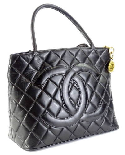 A Chanel quilted leather tote bag, in black, with over stitched CC logo to front and gold medallion embellished zipper, serial code to interior worn, serial code on authenticity card 8687435 (2003-2004), 25cm H, 32cm W, 14cm D.