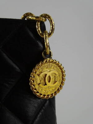 A Chanel quilted leather tote bag, in black, with over stitched CC logo to front and gold medallion embellished zipper, serial code to interior worn, serial code on authenticity card 8687435 (2003-2004), 25cm H, 32cm W, 14cm D. - 2