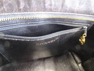 A Chanel quilted leather tote bag, in black, with over stitched CC logo to front and gold medallion embellished zipper, serial code to interior worn, serial code on authenticity card 8687435 (2003-2004), 25cm H, 32cm W, 14cm D. - 3