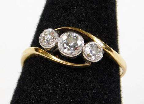 A Victorian diamond twist ring, set with three old cut diamonds, in rub over platinum setting, with twist design ring head, on yellow metal, marked 18ct, ring size Q½, 2.3g all in.