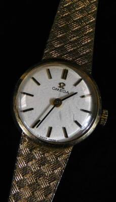 A ladies Omega 9ct gold cocktail watch, with textured bracelet and 2cm Dia. dial with baton numerals and pointers, 21g all in. (cased)