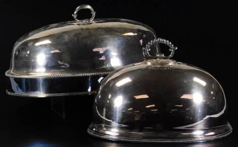 A 19thC silver plated meat cover, of oval form, with a gadrooned central banding, turned handle and engraved with a figure, 27cm H, 45cm W, 31cm D, and another smaller. (2)