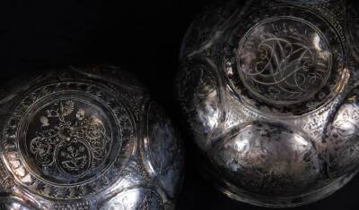 A 19thC travelling cup set, opening to the centre and producing two beakers, each with oval panels set with flowers and scrolls, on a part beaten body, with gilt coloured interior and script to each rim, white metal, 10cm H. - 2