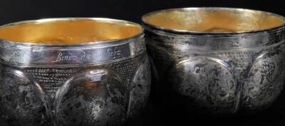 A 19thC travelling cup set, opening to the centre and producing two beakers, each with oval panels set with flowers and scrolls, on a part beaten body, with gilt coloured interior and script to each rim, white metal, 10cm H. - 3