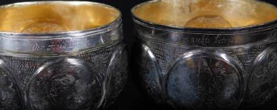 A 19thC travelling cup set, opening to the centre and producing two beakers, each with oval panels set with flowers and scrolls, on a part beaten body, with gilt coloured interior and script to each rim, white metal, 10cm H. - 4