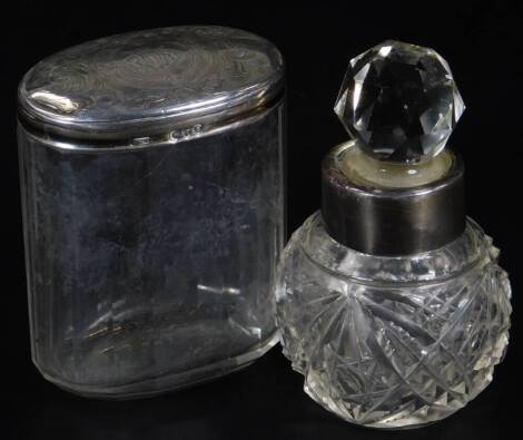 A Victorian silver and cut glass dressing table jar, with oval lid etched with scrolls, flowerheads and central initials, London 1894, 9cm H, and a further cut glass dressing table jar with orb stopper with silver collar. (2)