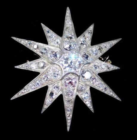 A late 20thC diamond star pendant/brooch, set with varying sized old cut diamonds, the central stone approx 0.6cts, with twelve points, six on the first tier set with four graduated diamonds, the lower six points set with three graduated diamonds, total e