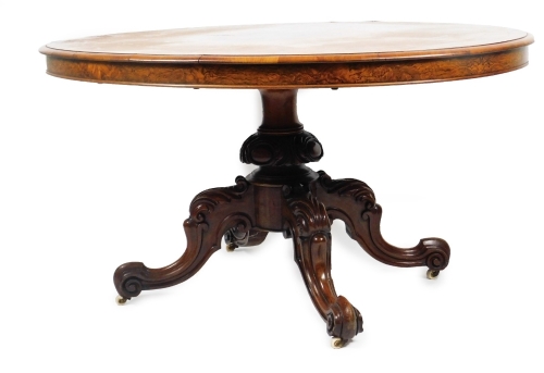 A Victorian walnut and string inlaid loo table, of oval form, on a heavy baluster stem terminating in quadruple carved cabriole legs with scroll feet, terminating in castors, 82cm H, 147cm W, 115cm D.