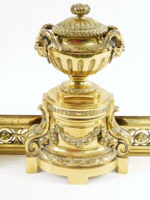 A Regency style metal fire surround, comprising of a pair of andirons surmounted by urns with satyr mask heads, with fixed lids, on acanthus scroll supports and a block base, joined by a rectangular grate front, with a pierced repeat floral pattern, 36cm - 2