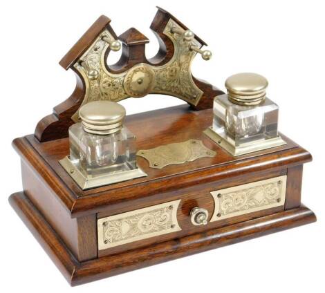 A late 19thC oak desk stand, with metal mounts, two ink bottles and front drawer, set with a plaque reading Presented To Mr C H Wykes, Gresford Church Choir, 19cm H, 24cm W, 18cm D.