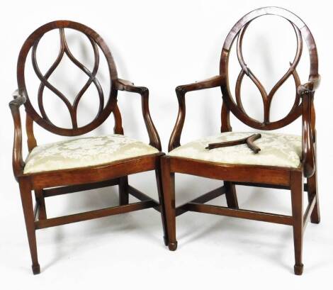 A pair of George III mahogany carver chairs, in the manner of Hepplewhite, with oval entwined splats, shaped scroll arms, inverted arm supports, serpentine drop in seats in later floral silk material, on square tapering front legs terminating in spade fee