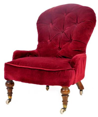 A Victorian nursing chair, in button back claret material, on turned front legs terminating in pot castors, 77cm H.