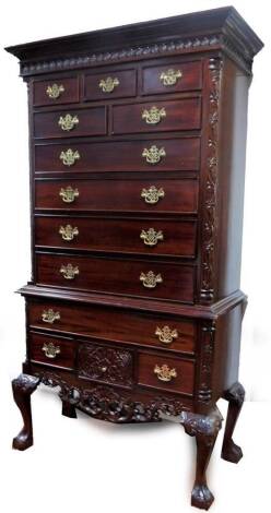 A George III style mahogany chest on stand, the upper section with a repeat floral frieze, raised above five short and four long cockbeaded drawers with plate back handles, the stand with two further drawers, on cabriole claw and ball feet, 186cm H, 102cm