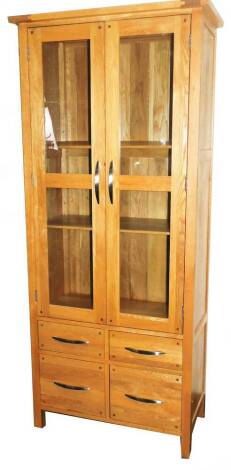 A light wood display cabinet, with two doors above four drawers, on square stiles, 184cm H, 85cm W, 41cm D.